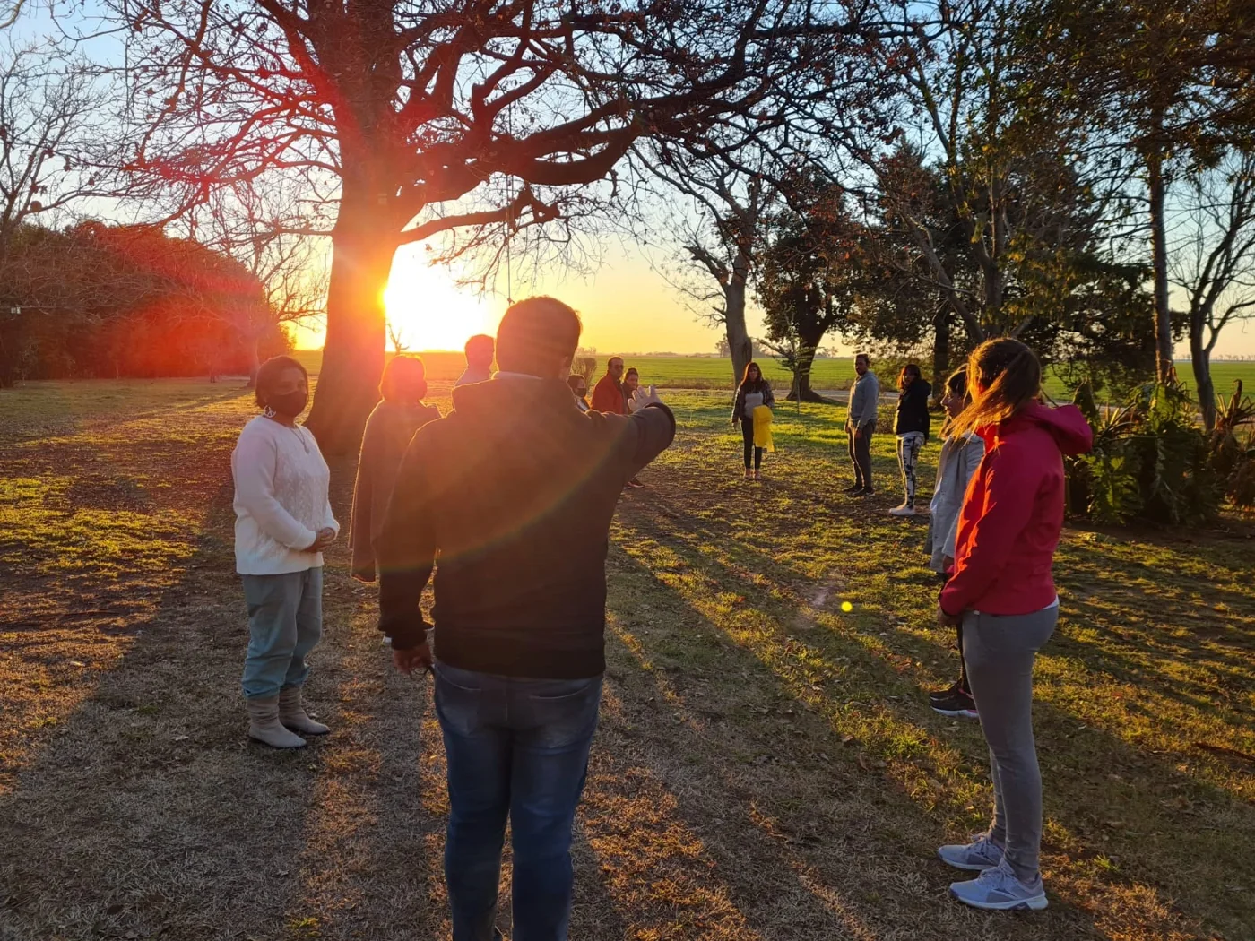 Estudiantes participando de una dinámica al aire libre al atardecer